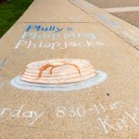 Sidewalk chalk art of a stack of pancakes promoting Family Weekend Pancake Breakfast.